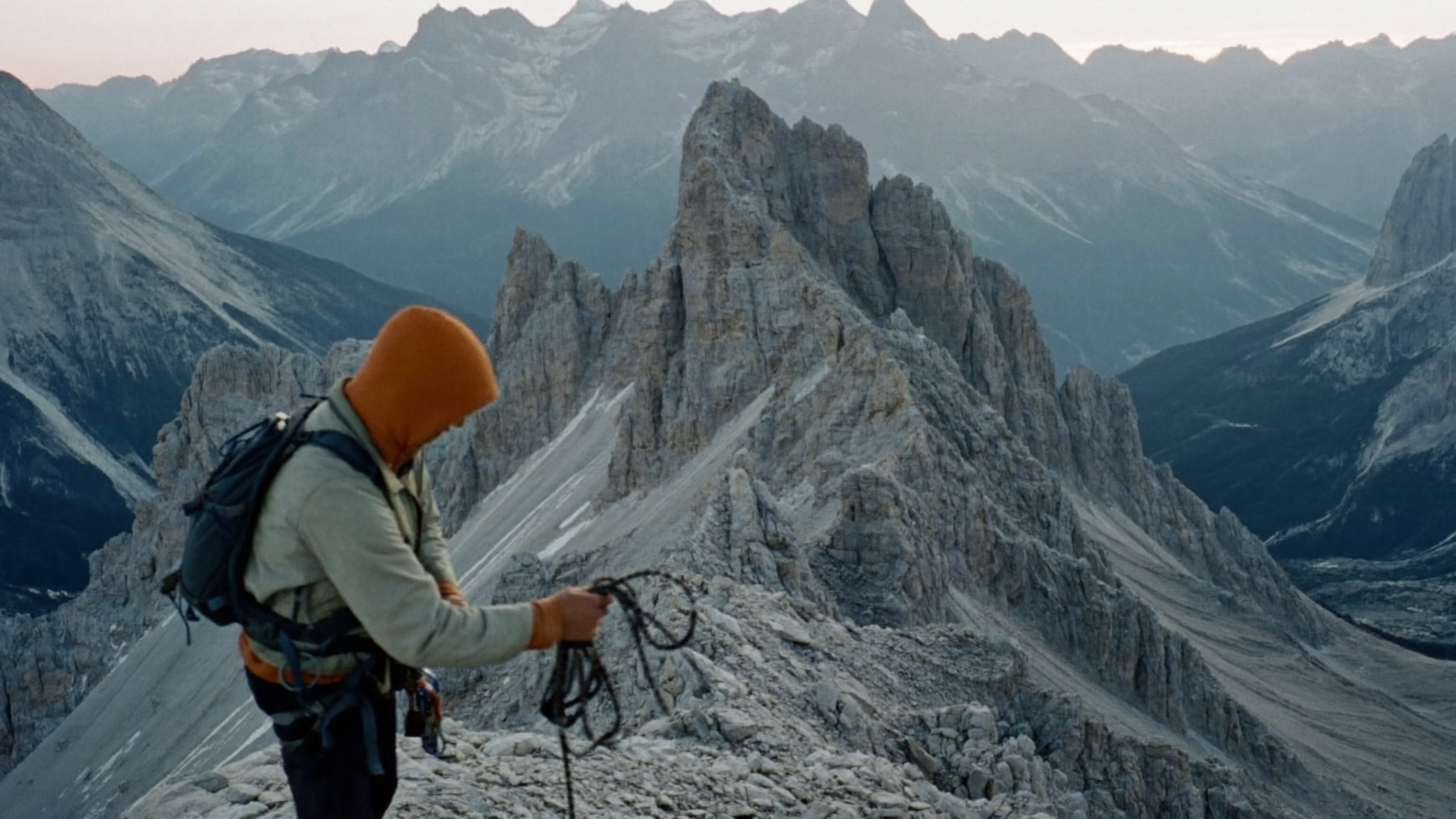 Concept image of an alpine guide preparing climbing ropes on a mountain ridge
